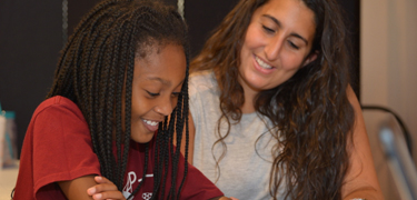 Student reading with a mentor