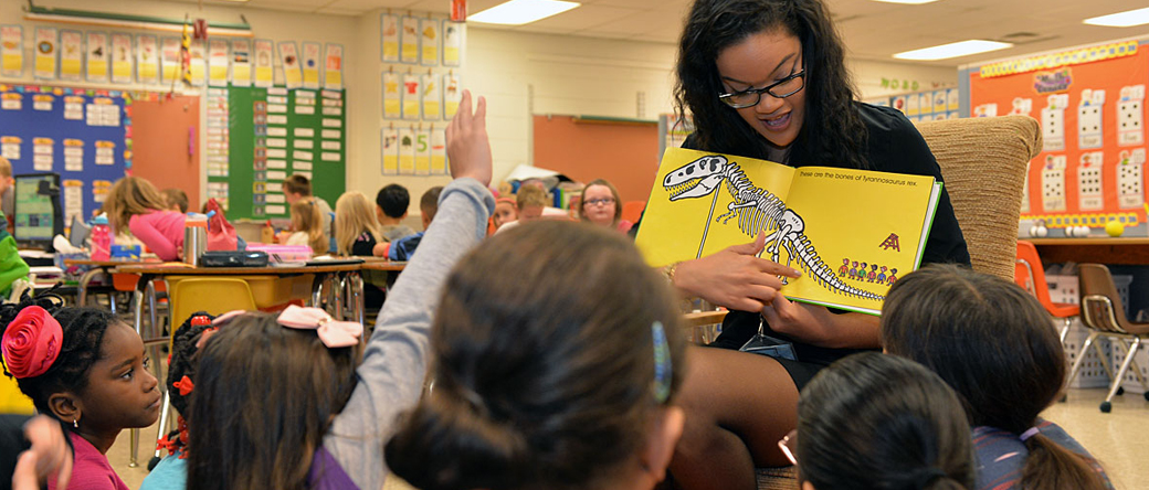 Woman reading to an elementary classroom